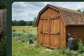 Barn-style wooden storage shed beside a garden